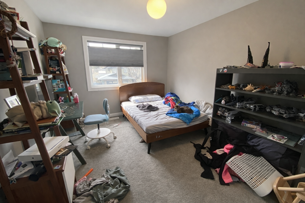 Bedroom prior to pre-listing preparation, with personal items visible and an unrefined furniture layout